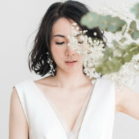 Woman in white sleeveless top with white flower